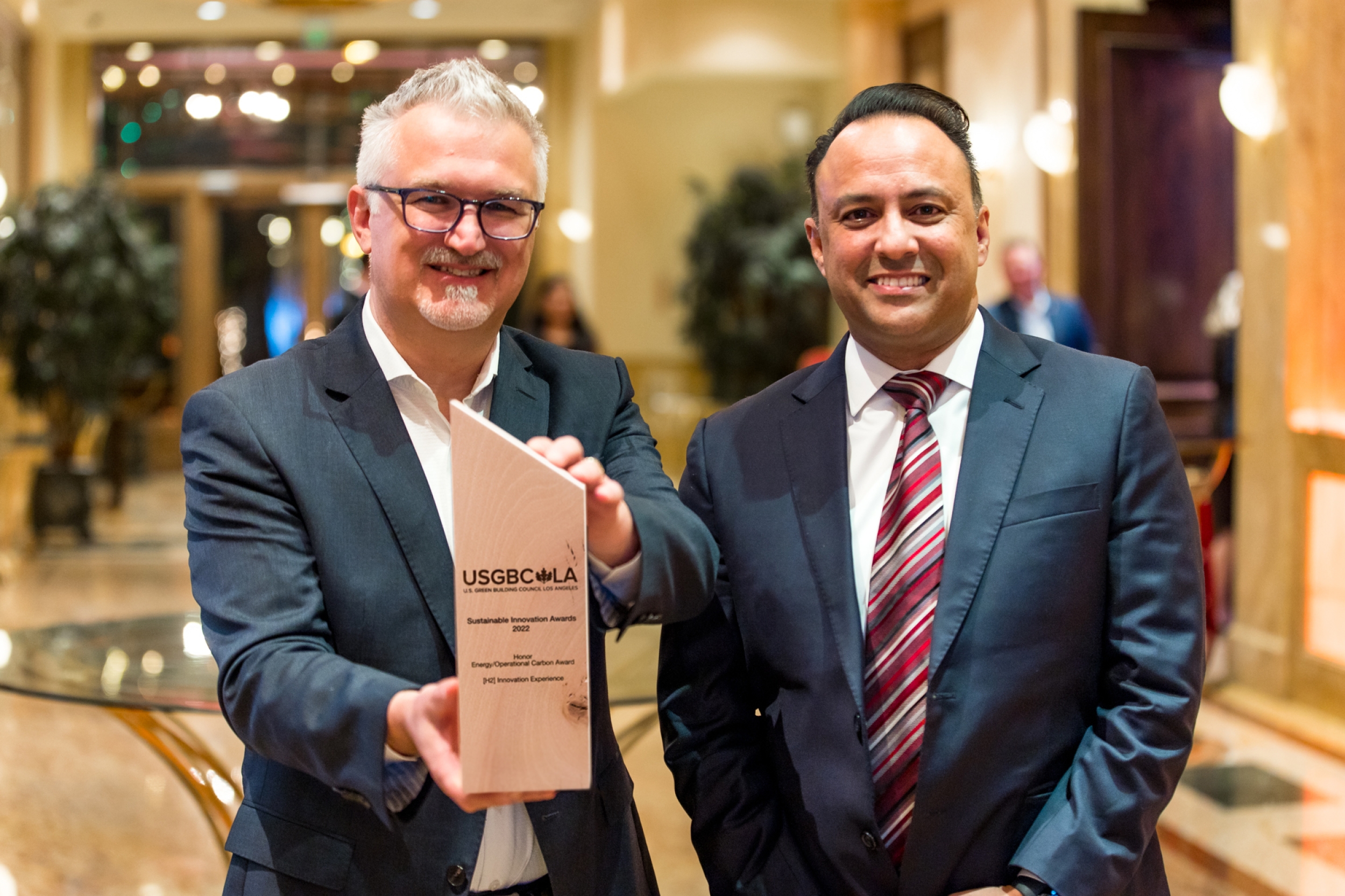 Neil Navin, vice president, clean energy innovations, and Jawaad Malik, vice president of strategy and sustainability, and chief environmental officer, accept the USGBC-LA sustainability award.