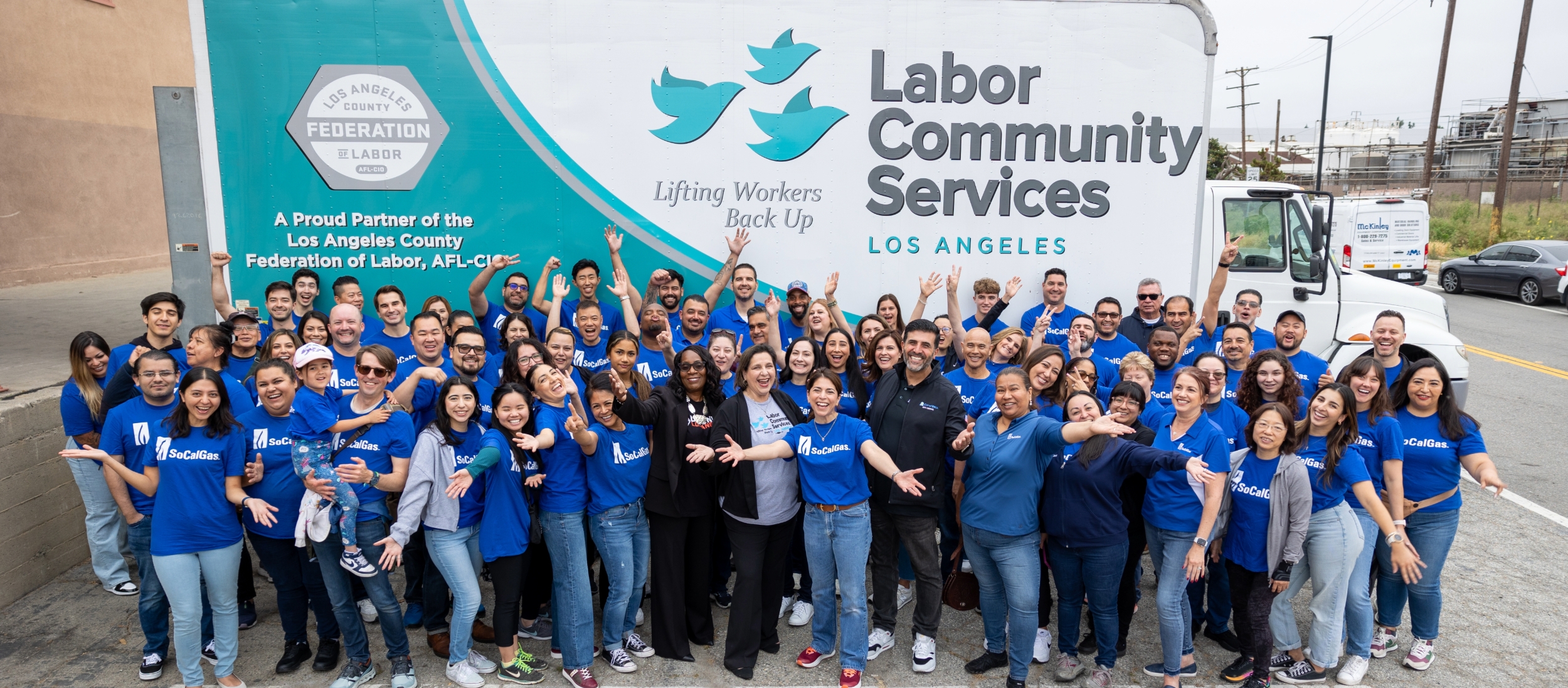 A group of SoCalGas employees are standing in front of a labor community services van.
