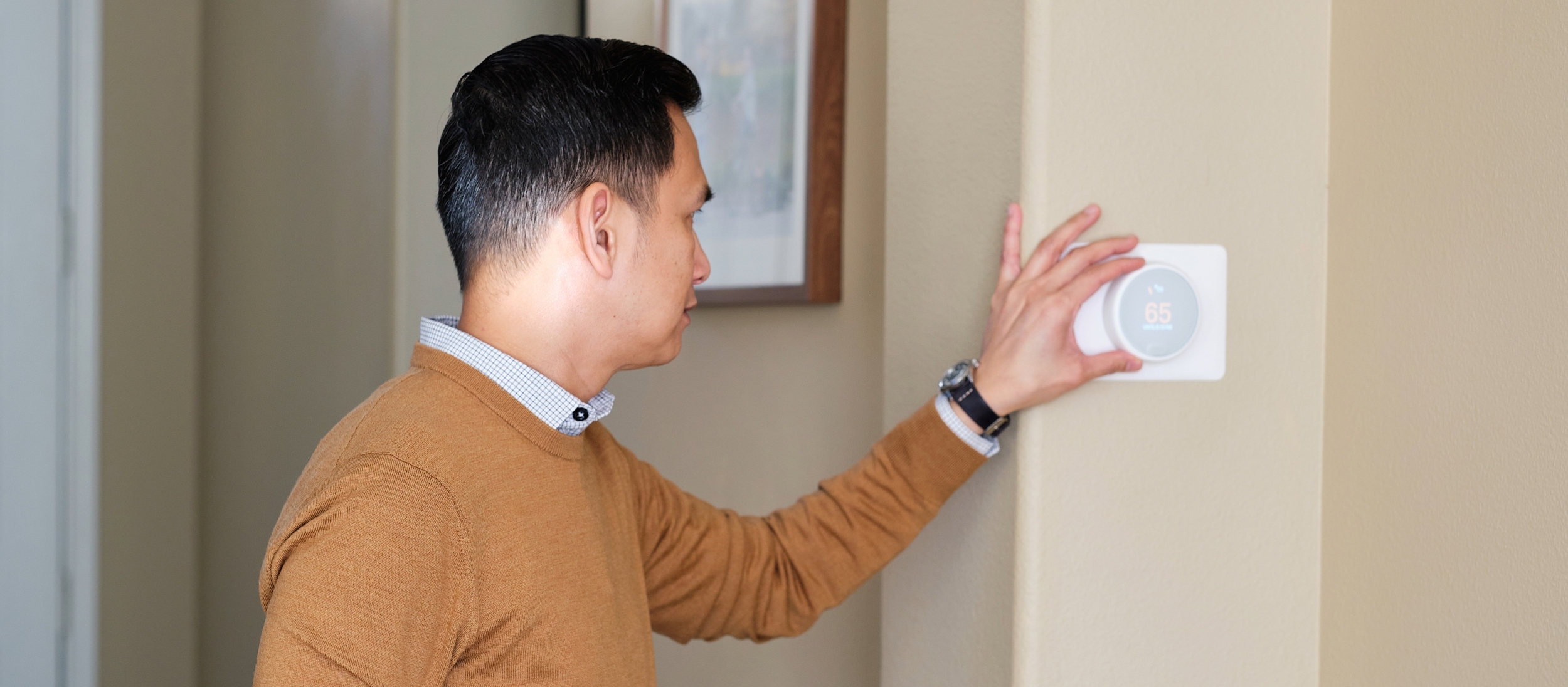 Person adjusting the thermostat