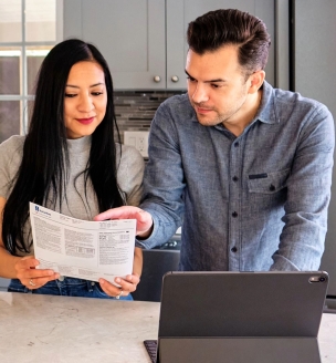 Two people looking at their utility bill in the kitchen