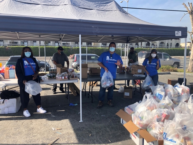 People wearing masks with bags of food